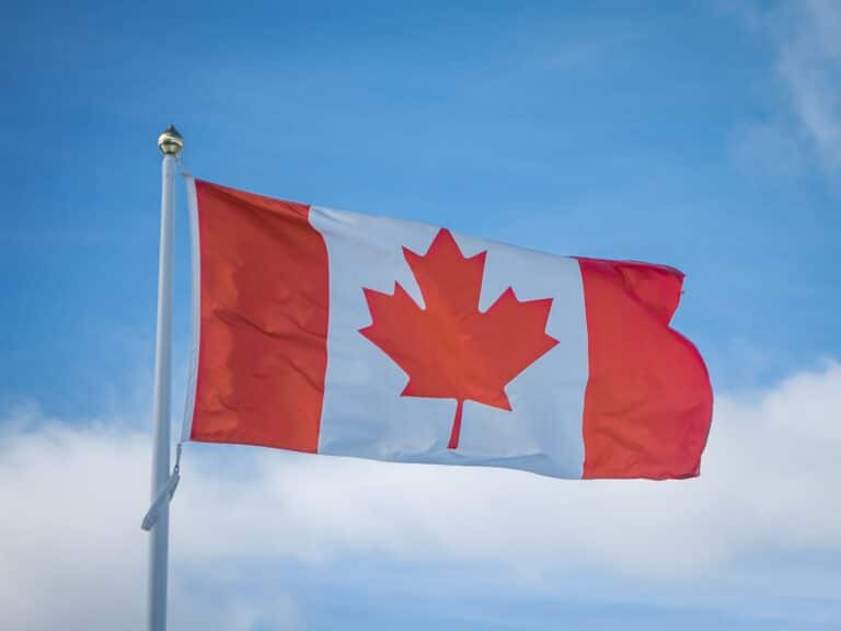 Canadian flag against a blue sky.